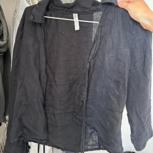 Blus  - Svart blus med knytningar i armarna och där man stänger den. Ena bandet sitter lite dåligt men ingen större fara, skriv för mer bilder! 