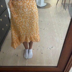 Orange maxi kjol - Orange kjol i mycket bra skick, ner till vaderna med en rosett i vänstra sidan 