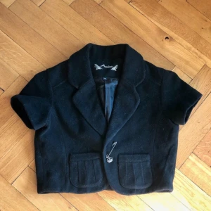 Kortärmad kavaj - En kavaj med sött spänne och fickor 