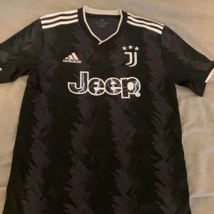 Fotboll jersey  - Säljer min Juventus t-shirt. Märket och klubbens loga är broderat. Tröjan är i perfekt skick och ser helt ny ut. Tröjan är äkta