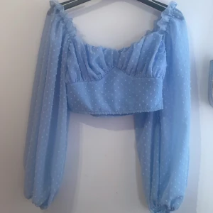 Fin sommar tröja  - Magtröja i ljus blå, blommer på den och puffig vid armarna, aldrig använd säljer, pgrund av att dne tyvärr int passar