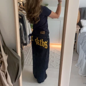 Baggy Junkyard Jeans - Mörkblå baggy jeans med gul text på baksida🙌🏼Använda max 3 gånger så väldigt bra skick. Nya på hemsidan kostar 799kr! Osäker på storlek med tror XS/XSS. Kontakta gärna vid fler frågor😇