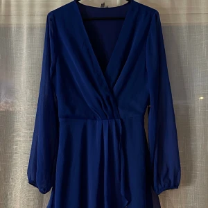 Klänning - Mörkblå chiffong klänning från Nelly. Köpte den för 400 kr och den är använd en gång🥰  Säljer för att jag inte har någon användning för den💫  Nelly säljer inte längre den här blåa men den svarta klänningen är i samma modell, så ni vet hur den ser ut🤗