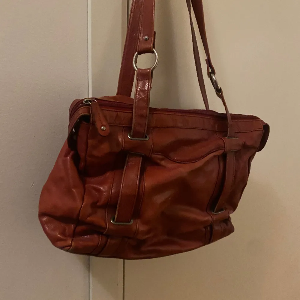 fin röd handväska som är lagom stor till skolan+man får plats med en dator i. ganska välanvänd men ändå fint skick den är ifrån the monte och den här modellen säljs inte längre skriv privat om ni vill ha mer ditajer . Väskor.