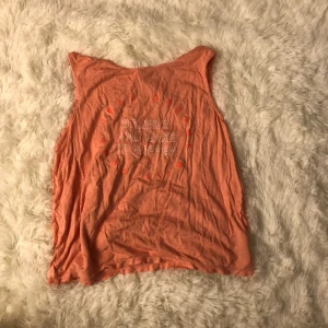 Ett  rosa linne med tryck  - Ett rosa linne med en text som står cirkel format dreams Will come true i neon rosa typ och inne i cirkeln står de Belive and make it happen i vit