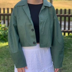 Skinnjacka - Grön skinnjacka från AFJ x NA-KD. Boxing modell med ballong ärmar. Har fickor på båda sidorna. Har fått lite fläckar på insidan, men inget som påverkar plagget, kan skicka bild om så önskas. Utsidan är i bra skick, endast använd fåtal gånger. 💚