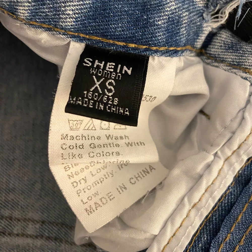 Ett par grå jeansbyxor från Shein i storlek XS. Byxorna har en rak passform och är tillverkade i bomull. De har en klassisk design med fyra fickor och knappgylf.. Jeans & Byxor.