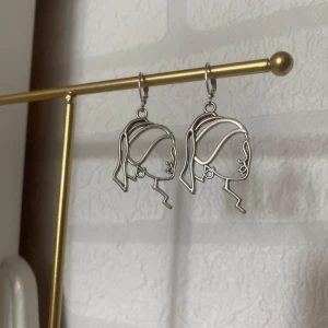 Örhängen  - Jättecoola örhängen av kvinnoansikte i rostfritt stål och zinklegering 💓Modell ”Saga”