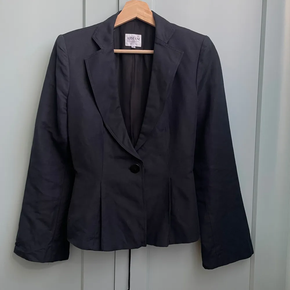 Fitted Vintage Armani Woven Blazer in Dark Navy. Adjustable Corseting detail in the back for the perfect silhouette. Features Side pockets and 1 button frontal closure. Made in Italy. Very Good Condition. Tagged Size 42. . Kostymer.