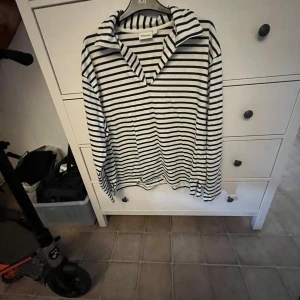 Svartvit randig tröja från Kappahl - En svartvit randig tröja från Kappahl i storlek L. Tröjan har långa ärmar och en krage.