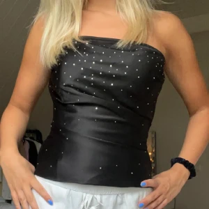 Korsettopp med glitter - Superfin korsettopp med stenar från Mariposa. Endast använd ett fåtal gånger så är i nyskick. Pris är diskuterbart vid snabb affär!