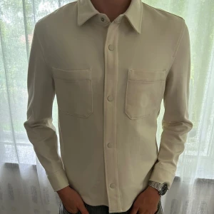 Vit Zara overshirt - Vi säljer nu denna vita overshirt från Zara i storlek M.  Skick: 9/10 Modellen är 185 cm och väger 75kg Nypris: 559kr Vårt pris: 219kr