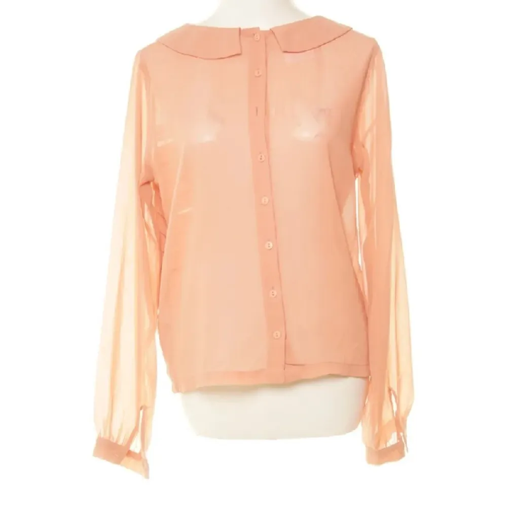 Båda sidor kan vara framsidan så det är som två tröjor i en. Färgen är mer rosa-aprikos än på bilden. Skjortor.