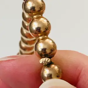 Vackert halsband med guldfärgade pärlor  Okänt material 