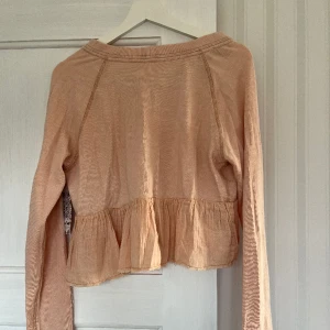 Free people blus - Aldrig använd, lapp kvar!  Rosa blus i sweatshirt liknande material, med volang nertill. 