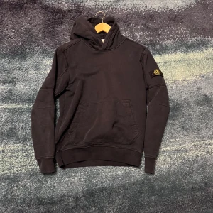 Svart stone island hoodie - Står att det är junior men passar small herr. Ett litet hål på armen som man inte ser 