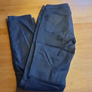 Svarta skinny jeans med vaxliknade utseende. W28 L32.