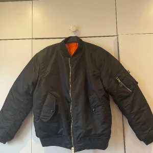Bomber jacka - Unisex MA1 svart bomber jacka med orange foder. Använd 1 gång. Storlek L. Skick 10/10. Nypris 799:- 