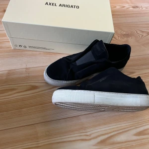 Axel Arigato 360 Laceless (prissänkt) - Axel Arigato 360 Laceless sneakers är en modern skomodell känd för sin eleganta design och höga kvalitet. Dessa sneakers har en minimalistisk estetik med en slip-on-design, vilket innebär att de inte har några skosnören.  Fin skick Allt finns med.