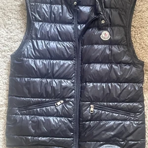 Moncler Gui - En väldigt fin Moncler Gui väst som tyvärr har blivit för liten nu! Bytt zip och ett nåt hål som är så pass små att de inte läcker ut något.  Tveka inte att höra av er vid frågor!😄 