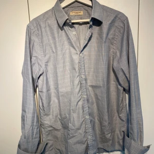 Burberry Oxford Skjorta ljusblå - Hej, säljer en lyxig skjorta från Burberry i ljusblått. Använd men i dugligt skick. Tailored fit. Storlek 40 vilket motsvarar Medium. Custom Croppad längst ner. Skön passform, passar till allt. Stilren & ikonisk. Pris kan diskuteras. Hörs i DM! 