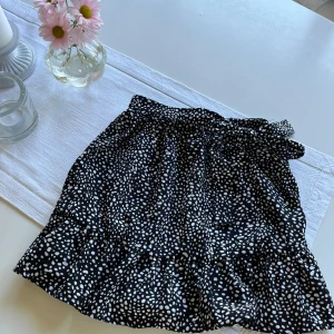 Utsvängd kjol - Svart och vit prickig kjol med knytband i sidan