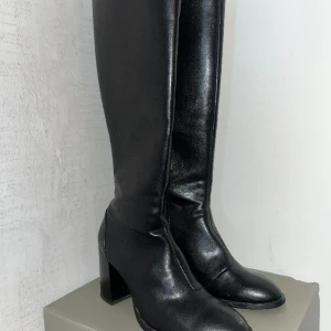 Knähöga boots - Säljer dessa superfina knähöga svarta boots ifrån bershka, endast använda två gånger. Köpta för 599. Har en liten skada längst fram på tån (var så när jag fick hem dom) men absolut inget man ser eller tänker på när de är på! Supersköna att gå i!