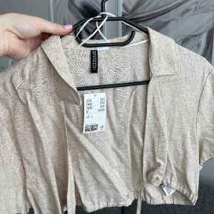 Ej använd topp i linnetyg från H&M, strl S - Fin topp i linnetyg med snörning från H&M i strl S. Toppen är aldrig använd då det aldrig blivit av, och prislappen är kvar! 