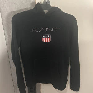 Gant Hoodie-Svart - Gant hoodie från Kidsbrandstore.  Riktigt bra skick och knappt använd.  Ord pris: 799 men säljer billigare. Pris kan diskuteras. Kommer inte till användning så valde att sälja den till någon fin människa som förtjänar den!❤️