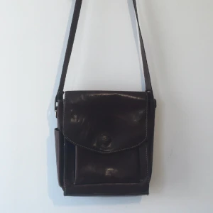 Läderväska  - Köpt secondhand i bra skick! Axelrem som går att justera ochmånga fickor!