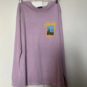 Långärmad stussy tröja - Skitsnygg lila långärmad stussytröja med tryck fram o bak som tyvärr är för liten.   Vid fler bilder, frågor eller mått skriv privat🥰