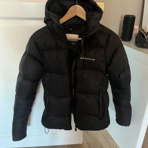 Dunjacka - Jättesnygg svart dunjacka ifrån märket Sail Racing. Jackan är använd vid väldigt få tillfällen så den är i väldigt fint skick. Kan gå ner i pris vid en snabb affär! Hör av dig om du har frågor.