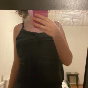 Svart linne med rosett framme  - Bra skick, sitter löst och är jätte fint att para med vad som, skriv om du är intresserad 