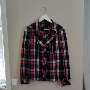 Skjorta med volanger  - Stilig skjorta med volanger på framsidan och ärmarna längst ner. Har ett tunnt skärp till. Fr. Esprit edc