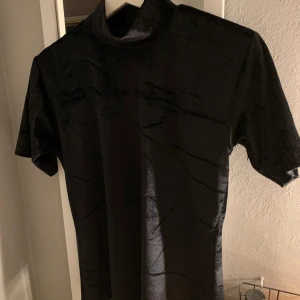 Svart kortärmad turtlenecktröja - Säljer min gamla favorittröja! Materialet är velour och den har dragkedja i nacken. Bra skick!