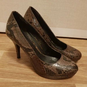 Högklackar äkta läder strl 37 från tamaris med stötdempare  - Högklackar äkta läder strl 37 Har ett litet släp på insidan se bild  Märke tamaris Har en stötdemar funktion i klacken som minskar skador på knäna  Köpt i Tyskland 