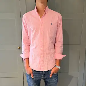 En rosa Ralph Lauren skjorta. Det är rutigt mönster. Storlek S, sitter M. Modellen på bilden är 188cm . Den är i bra skick. Hör av dig vid frågor eller funderingar// elegancecloset.