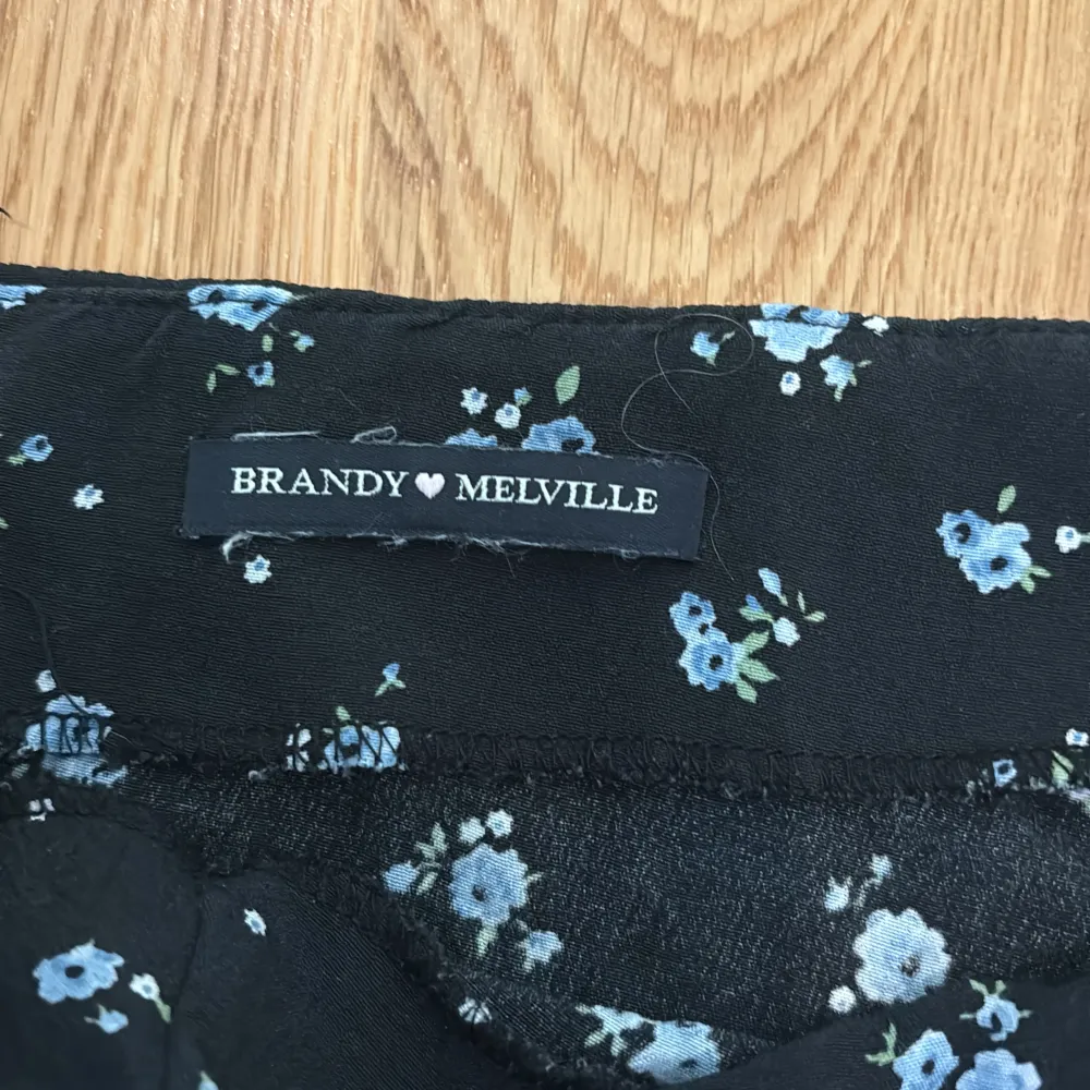 En mörkblå blommig brandy Melville kjol som slutar strax under knäna.Står inte storlek men passar en 34.Perfekt till skolavslutningen!. Kjolar.