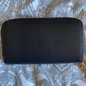 Plånbok - En stor och rymlig plånbok eller en lite mindre väska utan band. Säljer den då den inte kommer till användning🌷✨ Många fack och väldigt rymlig! På bild 3 är en jämförelse med en sminkborste. Skriv vid funderingar eller för fler bilder!