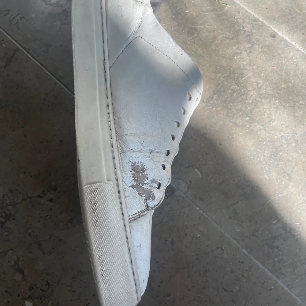 Välanvända vita Arigato skor. Creasade och färgen har lossnat på några ställen.. Skor.