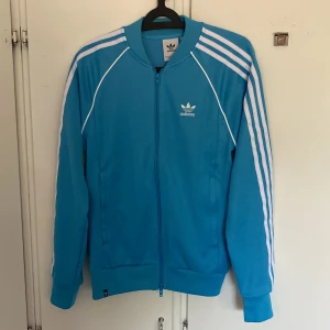 Adidas kofta - Ljusblå Adidas kofta i storlek S. Den är i bra skick och sällan använd. Säljer på grund av att den är för liten på mig!