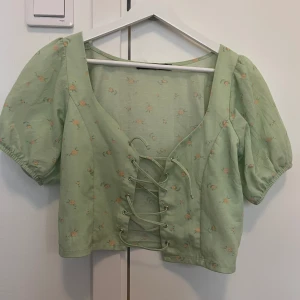 Blommig topp - Ljus grön blommig kortärmad blus från bikbok. Mycket bra skick använts få ggr.