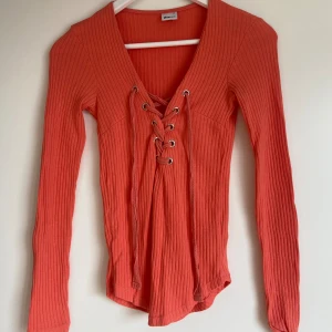 Jättefin långärmad topp - Jättefin topp med bad vid bröstet som Kan snytas/spännas åt hur man vill.  Den är fint skick!   Toppen kommer från Gina Tricot  Stl XS (normal i storlek)   Finns i organge, ljusrosa samt marinblå!!