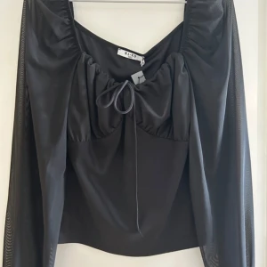 svart topp nakd  - säljer min svarta topp ifrån nakd passar både till fest och vardag, lappen kvar då det inte var min stil och hann inte lämna tillbaka!!