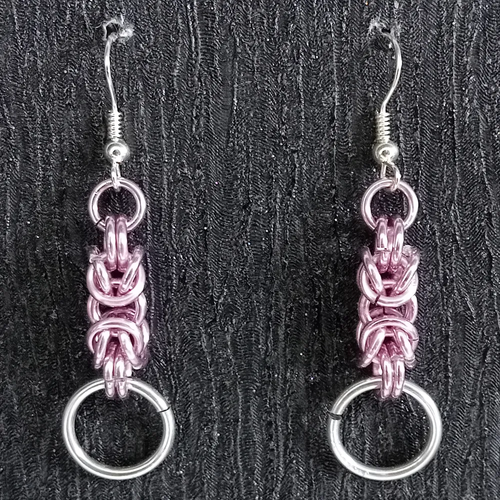 Ett par örhängen gjorda med rosa och silver ringer mått (ca 4.3 cm långa). Öronkroken är nickelsäker . Accessoarer.