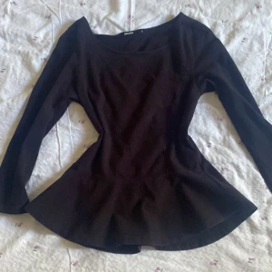 Trekvartsarmad volang topp - En topp med volanger parat med trekvartslånga armar från bikbok i storlek S.