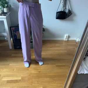 Lila kostymbyxor  - Lila kostymbyxor som är köpta här på Plick som jag har använt en gång på konsert men byxorna är i mycket bra skick. Byxorna är i S men passar som M men kanten går att vika ner
