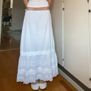 Vit långkjol - Vit långkjol med snygga spetsdetaljer. Innerbenslängd: 90 cm, den är väldigt stretchig i midjan så passar mellan xxs och m💕