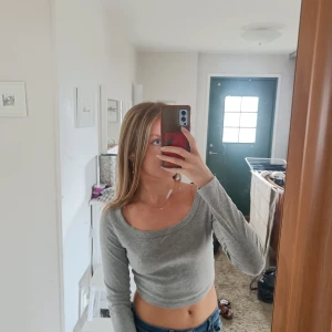 Långärmad tröja  - Långärmad grå tröja med djup urringning 