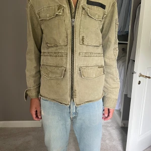 Zadig jacka herr - Militärjacka. Gammal kollektion typ 2018 finns ej kvar. Köpt för cirka 3500. En sömm har lossnat men går lätt att fixa själv eller hos skräddare. Passar M/L herr. Använd sparsamt. 